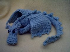 a crocheted blue hat laying on top of a white blanket