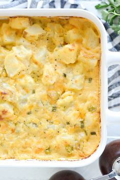 a casserole dish with potatoes and broccoli in it on a table