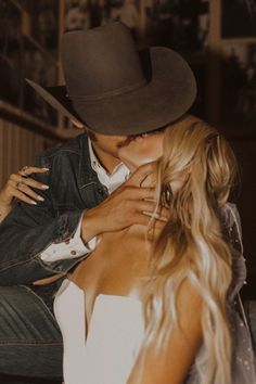 a man in a cowboy hat kissing a woman