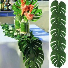 there is a vase with flowers in it on the table next to a large green leaf