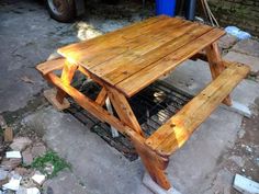 a wooden picnic table sitting on top of a cement ground