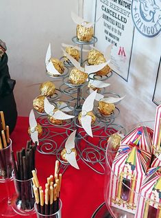 a table topped with lots of desserts and candy bar items on top of a red table cloth