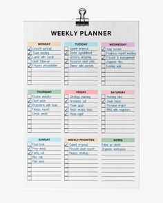 a printable weekly planner is hanging on a white wall with a clipping attached to it