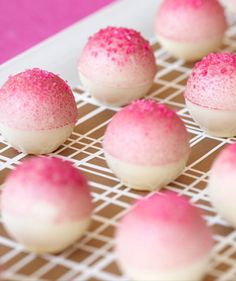 there are many pink and white desserts on the tray