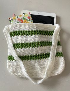 a crocheted bag sitting on top of a table next to an electronic device