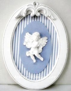 a blue and white plate with an angel decoration on the front, hanging from a wall