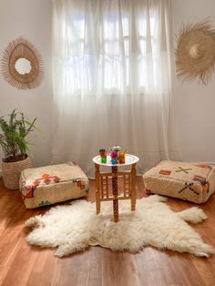 a living room filled with furniture and a white rug on top of a hard wood floor