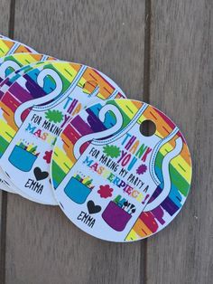 three stickers with different designs on them sitting next to each other in front of a wooden surface