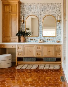 a bathroom with wooden cabinets and tile flooring, two mirrors on the wall above the sink