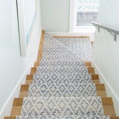 the stairs are lined with blue and white rugs