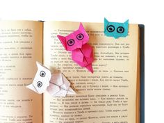 two origami owls sitting on top of an open book