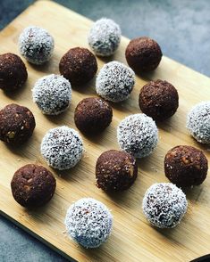 chocolate truffles are arranged on a cutting board with powdered sugar and sprinkles