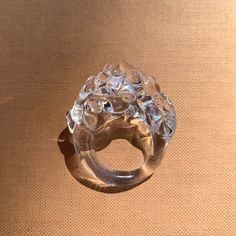 a clear glass ring sitting on top of a brown table next to a tan wall