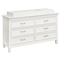 a white dresser with six drawers and two baby cribs on top of it