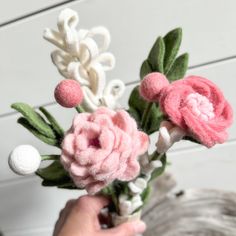 a person is holding some fake flowers in their hand and they are made out of felt