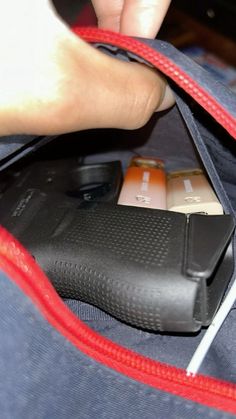 a person is opening the zipper of a bag with their cell phone and charger plugged in