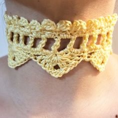 a woman wearing a yellow crochet choker with holes in the center and bottom