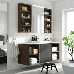 a bathroom with a sink, mirror and shelves on the wall next to a window