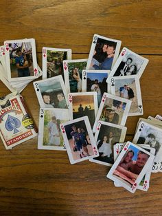 several playing cards with pictures of people on them sitting on top of a wooden table