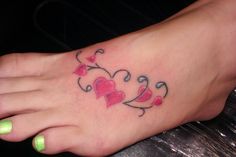 a heart tattoo on the foot of a woman