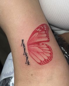 a red butterfly tattoo on the right side of the arm, with chinese writing below it