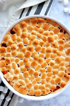 a white dish filled with marshmallows on top of a black and white towel