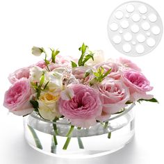 a vase filled with lots of pink and white flowers on top of a glass table