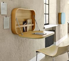 a wooden shelf mounted to the side of a wall next to a chair and table