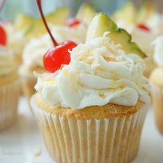 cupcakes with white frosting and cherries on top