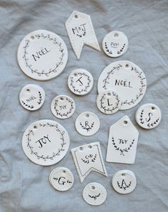 white tags and tags with black writing are arranged on a gray cloth covered tablecloth