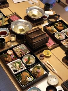 a table topped with lots of plates and bowls filled with different types of sushi