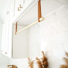 a bathroom with white cabinets and gold handles