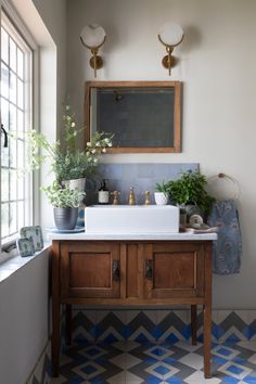 the bathroom is decorated in shades of blue and white, with an antique mirror above the sink