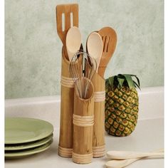 a group of wooden utensils sitting on top of a counter next to plates