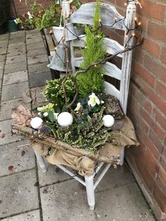 an old chair is decorated with plants and candles