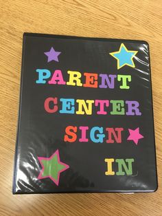 a sign that says parent center sign in multicolored stars on black paper with the words, parent center sign in rainbow letters