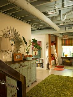 a living room filled with furniture and lots of green rugs on top of a hard wood floor