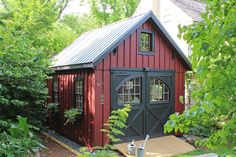 a red and black shed surrounded by trees