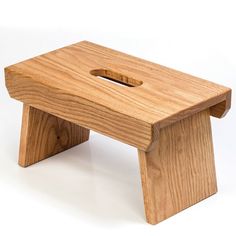 a small wooden step stool with a hole in the middle and one foot on it