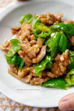 a white plate topped with meat and green peppers