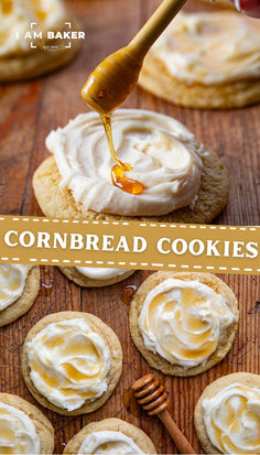 cookies with white frosting and honey being drizzled over them on a wooden table