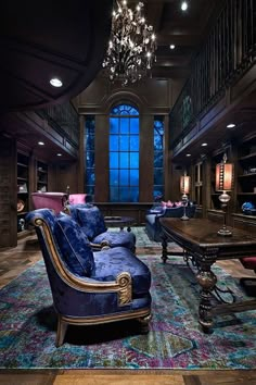 a living room filled with lots of furniture and a chandelier hanging from the ceiling