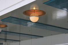 an overhead light fixture in a building with blue and white paint on the ceiling above it