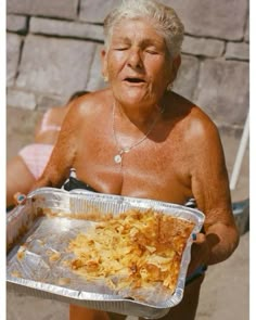 an older woman holding a tray with food on it