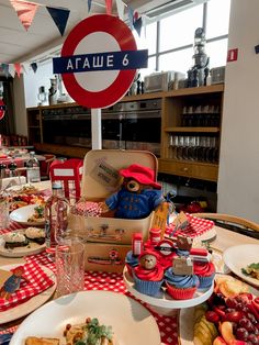 a table filled with lots of food on top of a red and white checkered table cloth