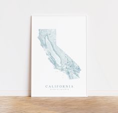 a white poster with the state of california on it in front of a wooden floor