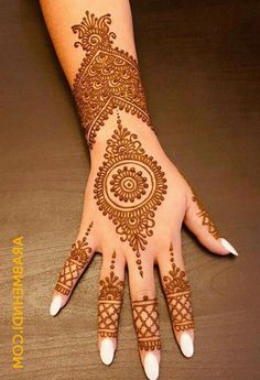 a woman's hand with henna tattoos on it