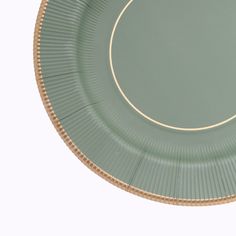 an empty green plate with gold trim around the edge