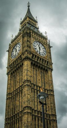 the big ben clock tower towering over the city of london, england on a cloudy day