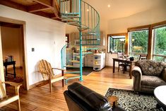 a living room filled with furniture and a spiral staircase in the middle of the room